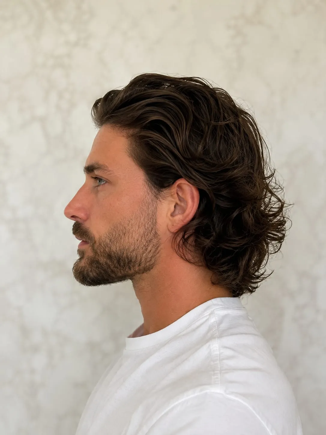 Coupe homme mi-longue aux ondulations naturelles, de profil