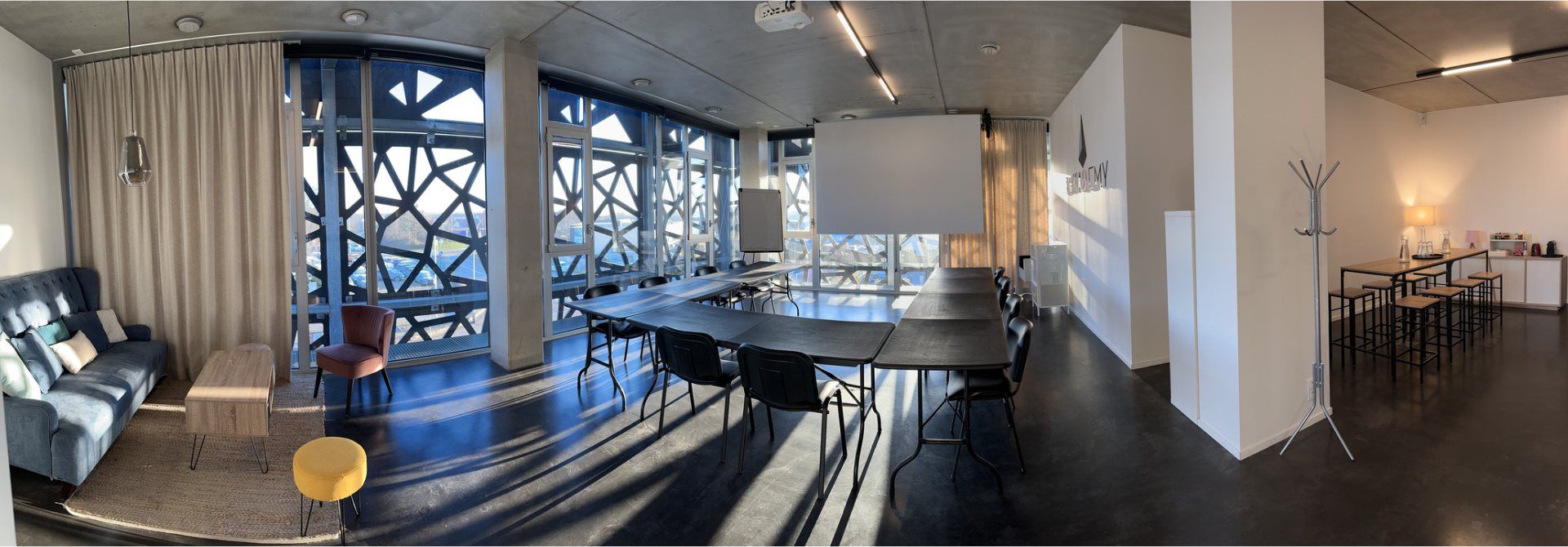 Vue panoramique de la salle de formation, de l'espace détente et des baies vitrées